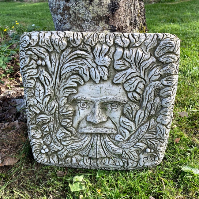 Plaque de béton en forme de visage feuillu
