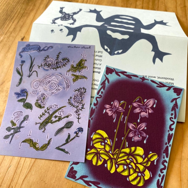 Planche de stickers végétaux, carte postale représentant des violettes sous la pluie, et lettre avec des batraciens stylisés.